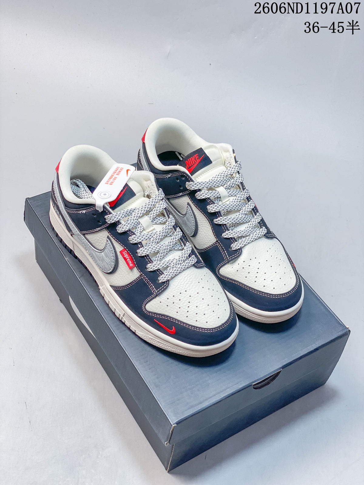 Pair of white, gray, and navy low-top sneakers with gray patterned Swooshes and light patterned laces.