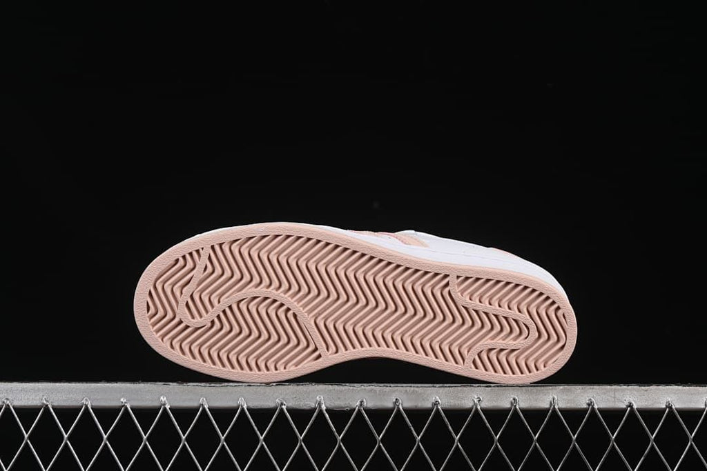 Underside of the sneaker showing a blush-pink herringbone-pattern outsole.