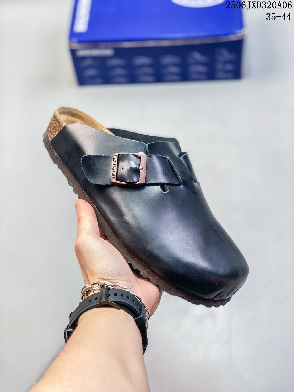Angled view of a black closed-toe clog with a buckle strap and cork-colored footbed edge; size range 35–44 is printed in the image.