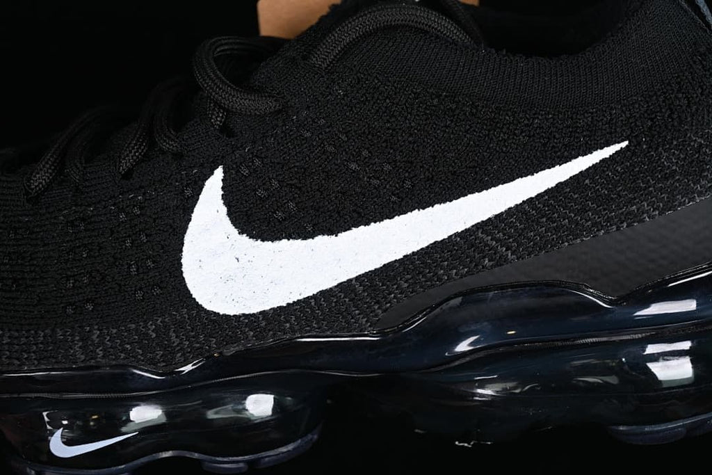Close-up of the black knit-style upper, white Swoosh, and sole.