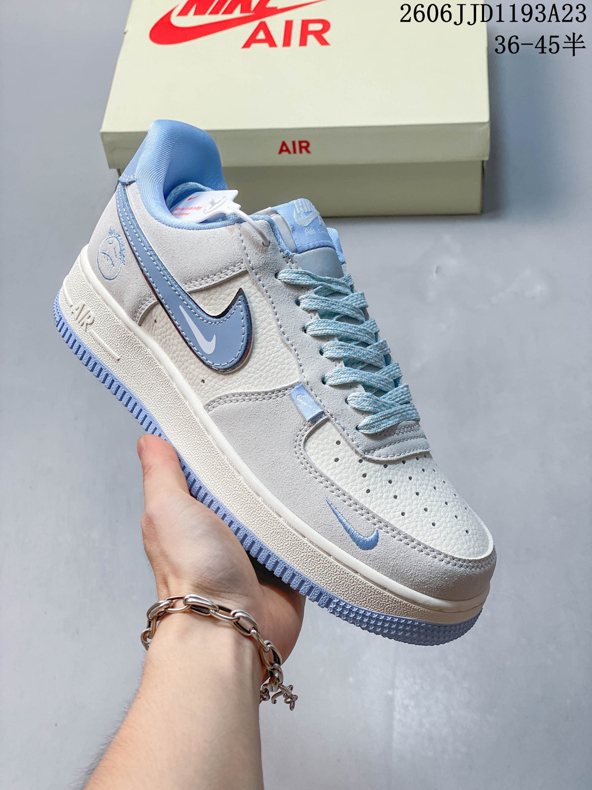Close view of a white and ice-blue sneaker with blue side Swoosh and heel graphic