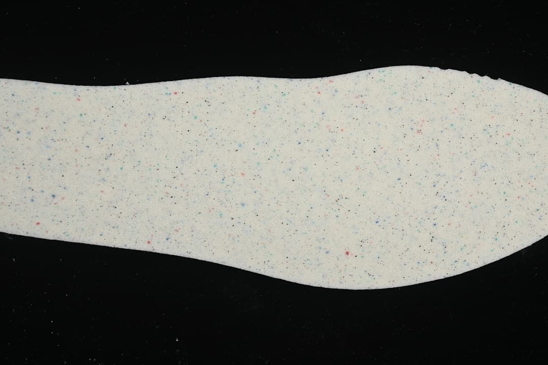 Light-colored sneaker insole with small multicolor speckles