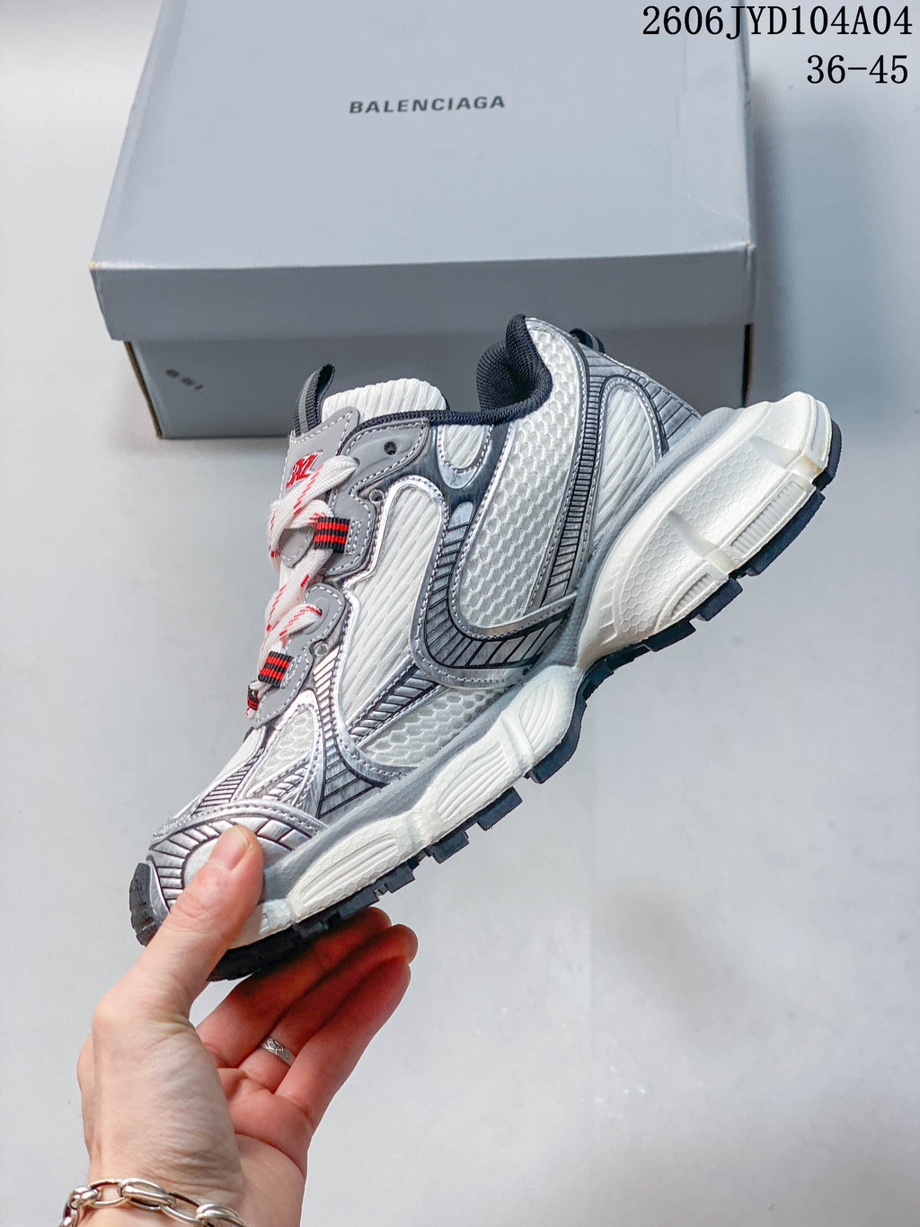 Side view of a white and gray chunky sneaker with layered panels