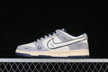 Side view of a grey, white, and navy low-top sneaker with contrast Swoosh detailing