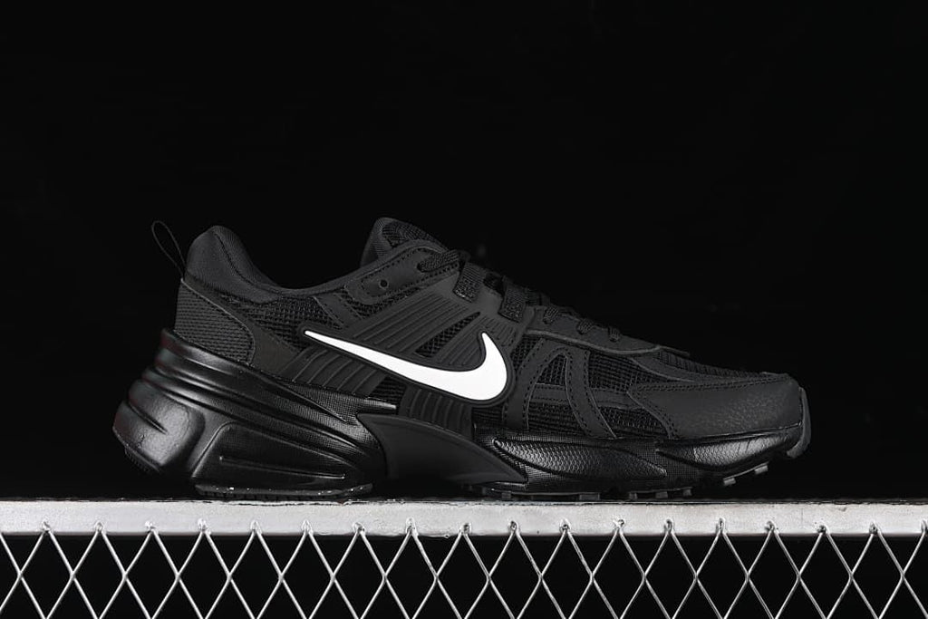 Side profile of the black sneaker with a white Swoosh.