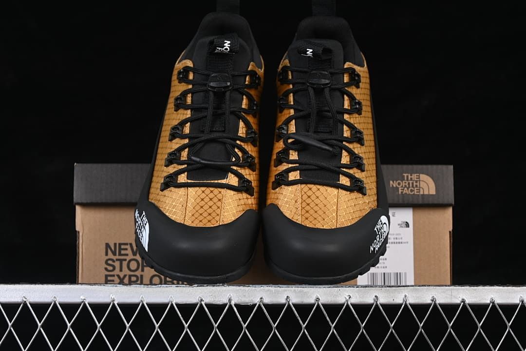 Front view of the pair with gold patterned uppers and black toe overlays