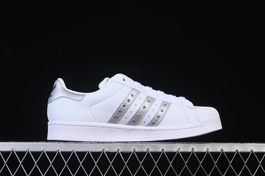 Side profile of the white sneaker with silver decorative stripes