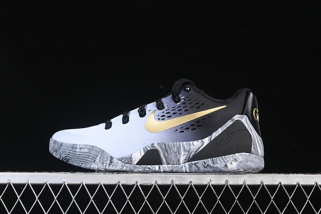 Side view of white and black low-top basketball shoe with gold Swoosh and marbled gray sole
