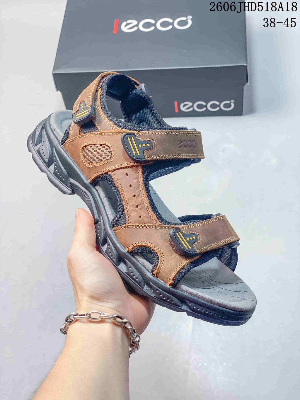 Angled side view of the brown and gray sandal with adjustable straps and open toe.