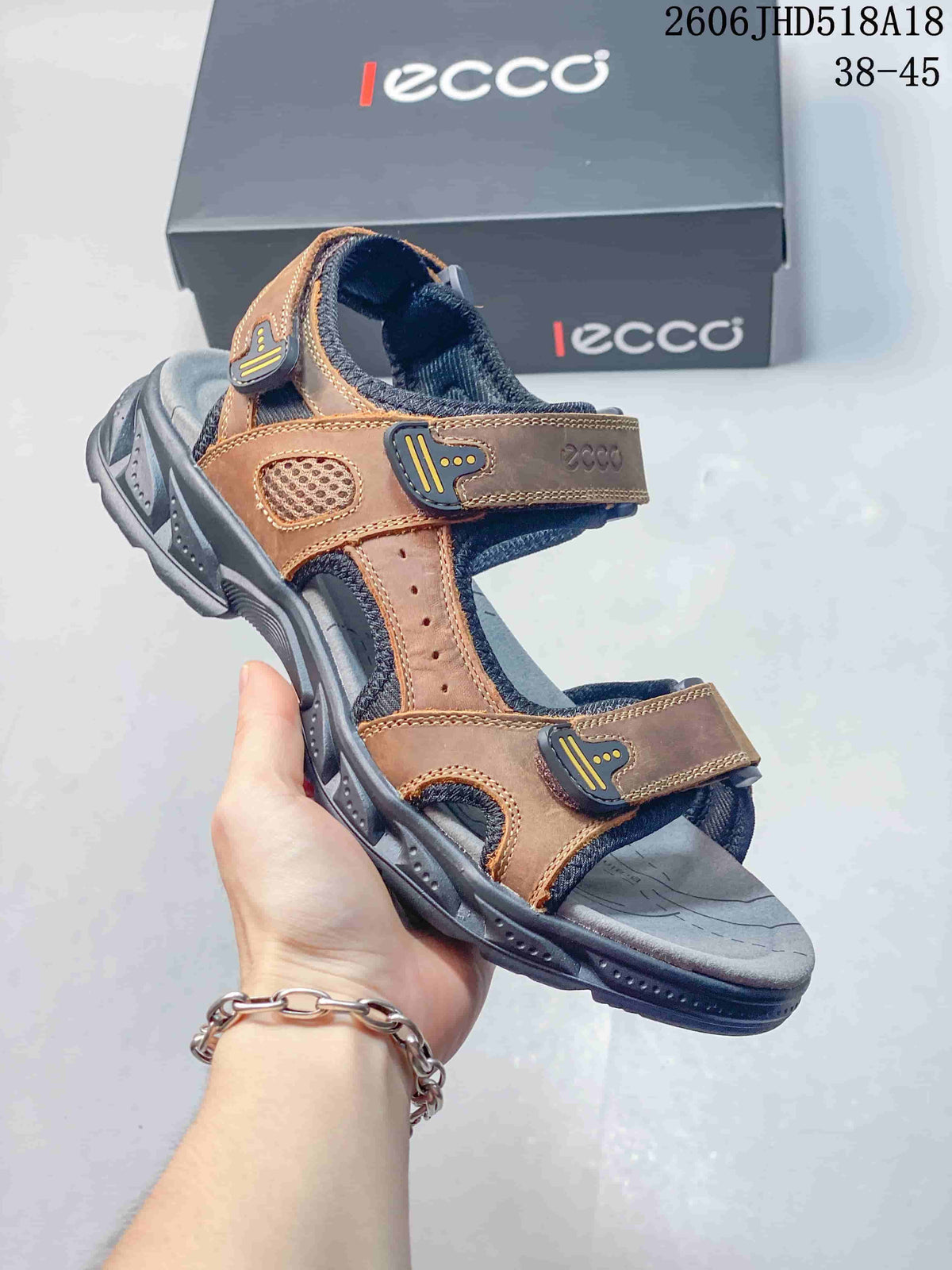 Angled side view of the brown and gray sandal with adjustable straps and open toe.