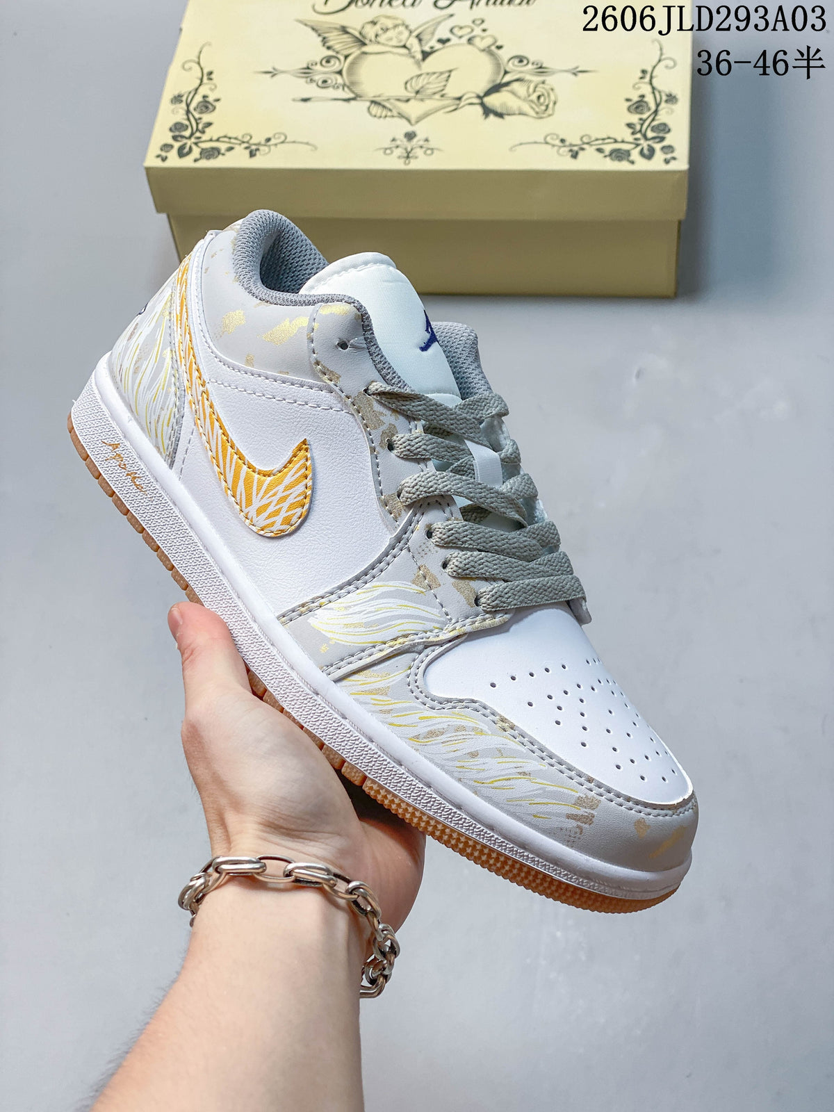 Angled side view of the white and light gray Jordan sneaker