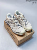 Pair of cream and sand-gray Salomon XA Pro 3D sneakers displayed on a shoe box.