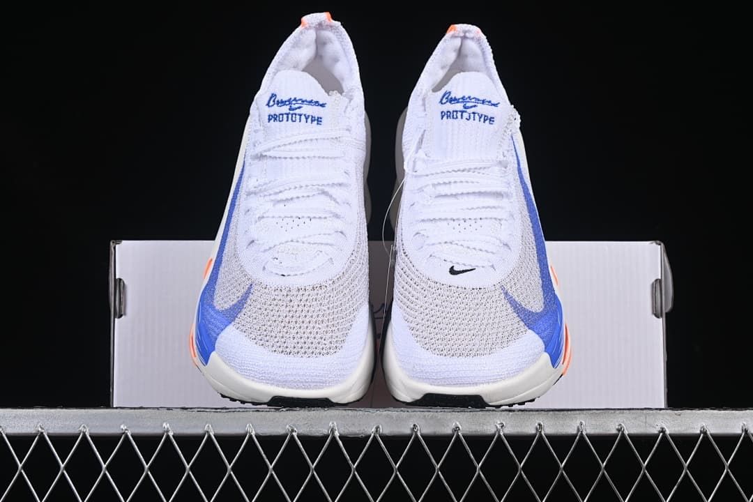 Front view of the pair of white shoes with blue and orange accents