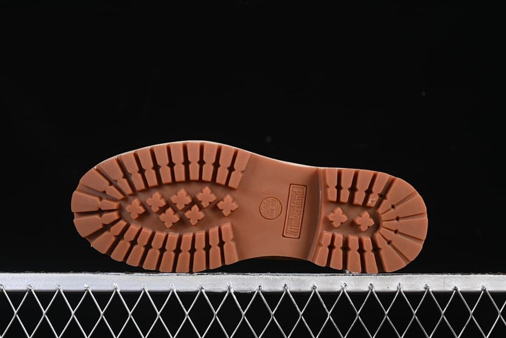 Underside view of the boot with deep lug tread and molded branding