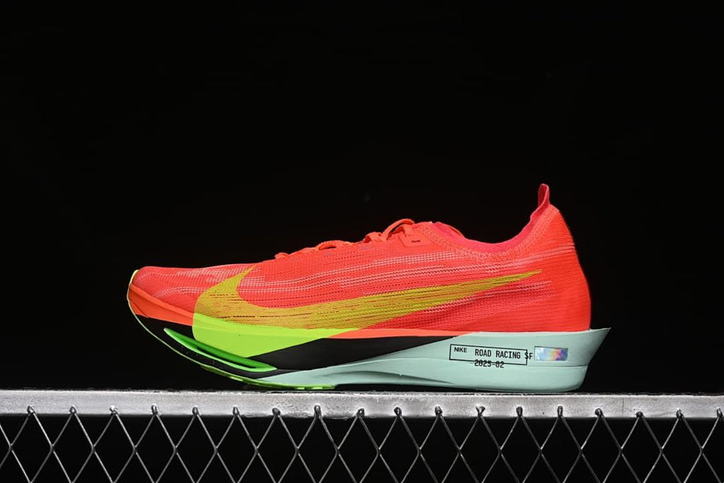 Side view of coral-red Nike ZoomX Streakfly 2 shoes with lime accents and a pale mint midsole.