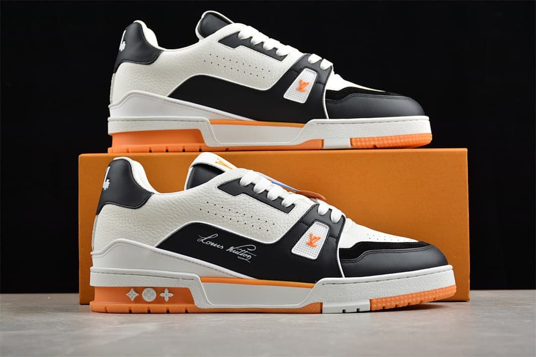 Two LV Trainer sneakers displayed in front of an orange shoebox