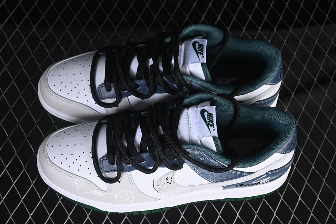 Top view of a pair of Nike SB Dunk Low sneakers showing perforated toe boxes, black laces, and dark green lining