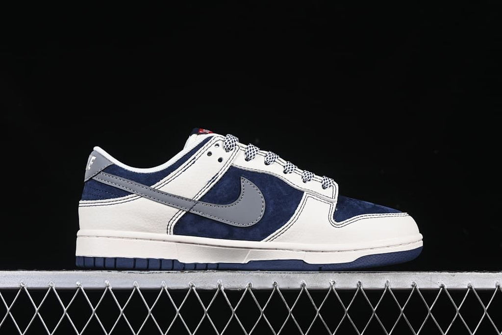 Side profile of a low-top sneaker with navy panels, gray Swoosh, and off-white sections.