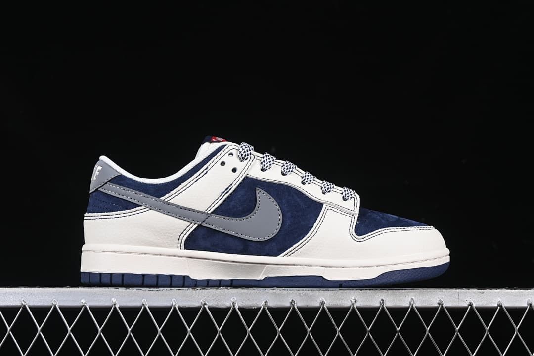 Side profile of a low-top sneaker with navy panels, gray Swoosh, and off-white sections.
