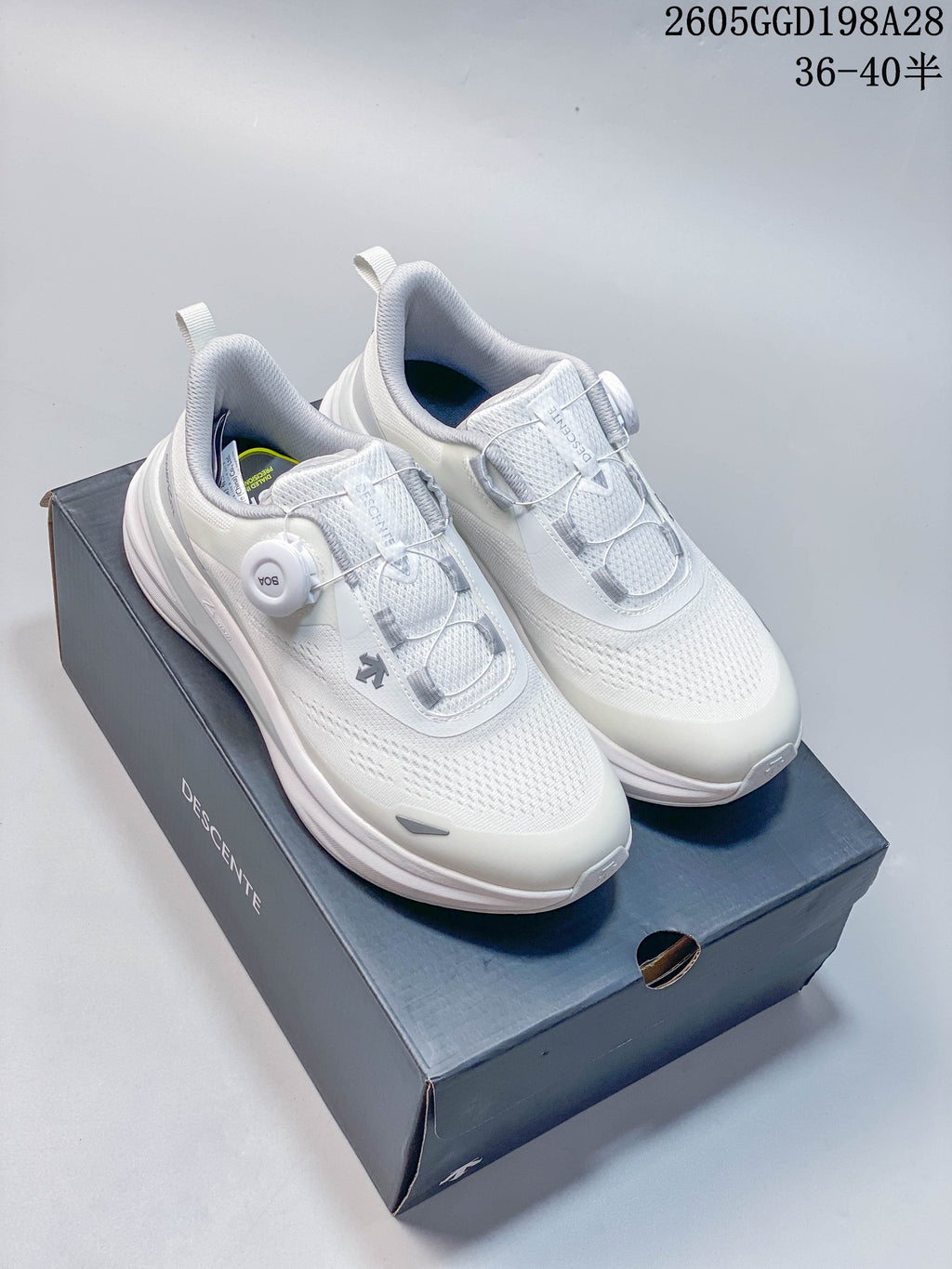 Pair of white knit DESCENTE BOA running shoes on a branded box.