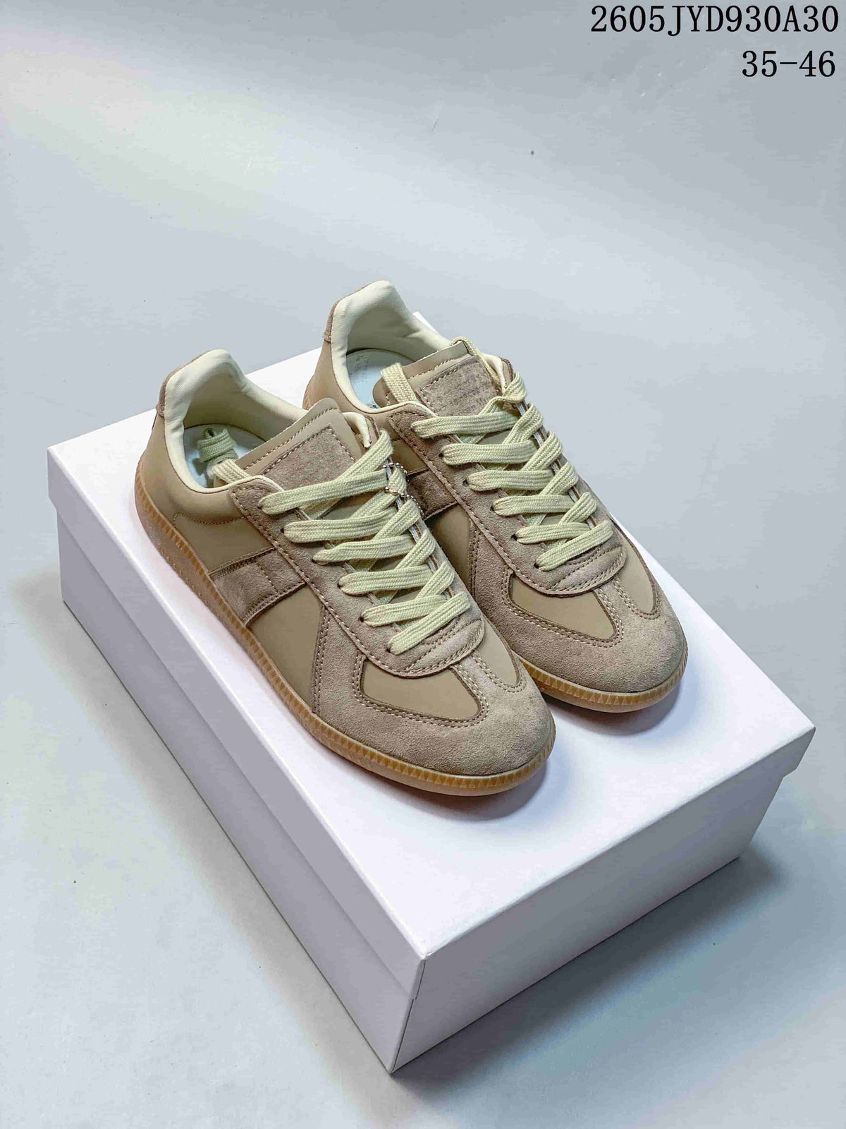 Pair of taupe low-top lace-up sneakers with pale laces and gum-colored soles, shown from above.
