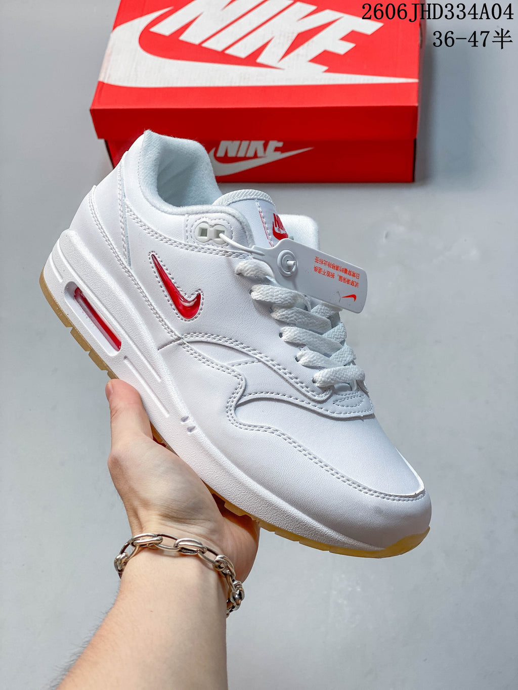 Nike Air Max 1 sneaker with textured gray overlays, dark blue accents, and a visible Air unit.