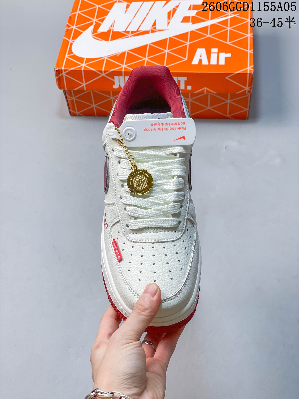Top view of the sneaker showing its perforated toe, white laces and decorative gold-tone charm