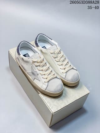 Pair of white and gray low-top sneakers displayed on a box