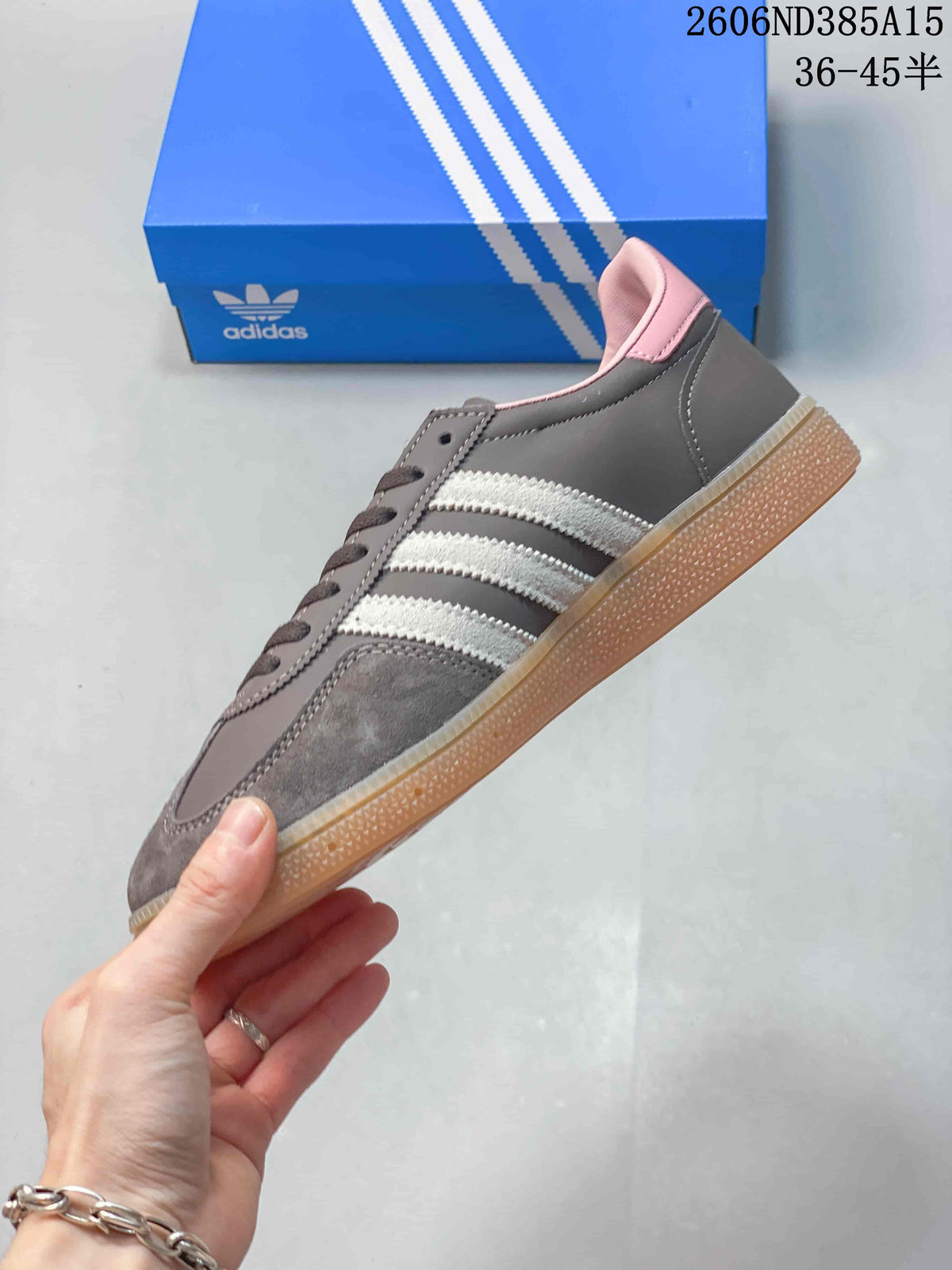 Side profile of the grey sneaker showing white stripes, pink collar details and gum-colored sole.