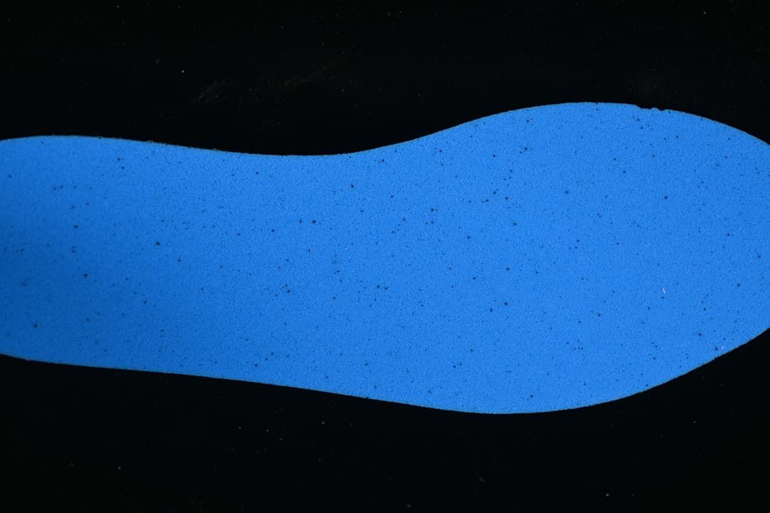 Blue shoe insert shown separately against a dark background.