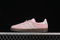 Side view of pink adidas Gazelle Indoor sneakers with pale stripes and a gum-colored sole