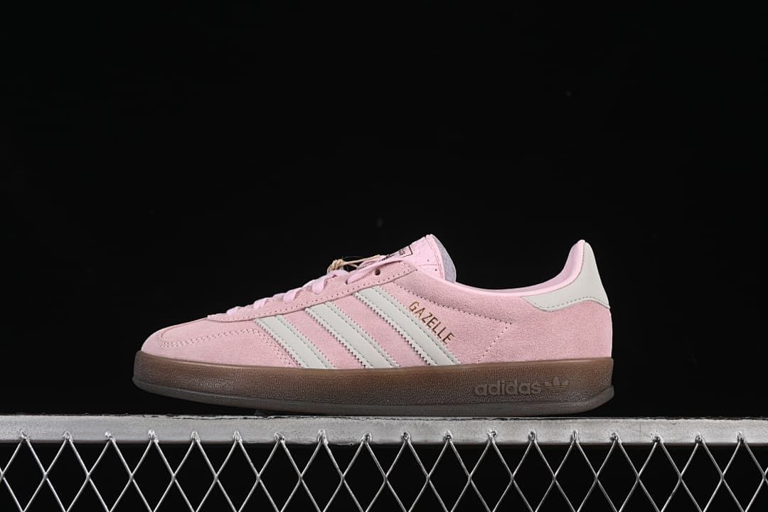 Side view of pink adidas Gazelle Indoor sneakers with pale stripes and a gum-colored sole