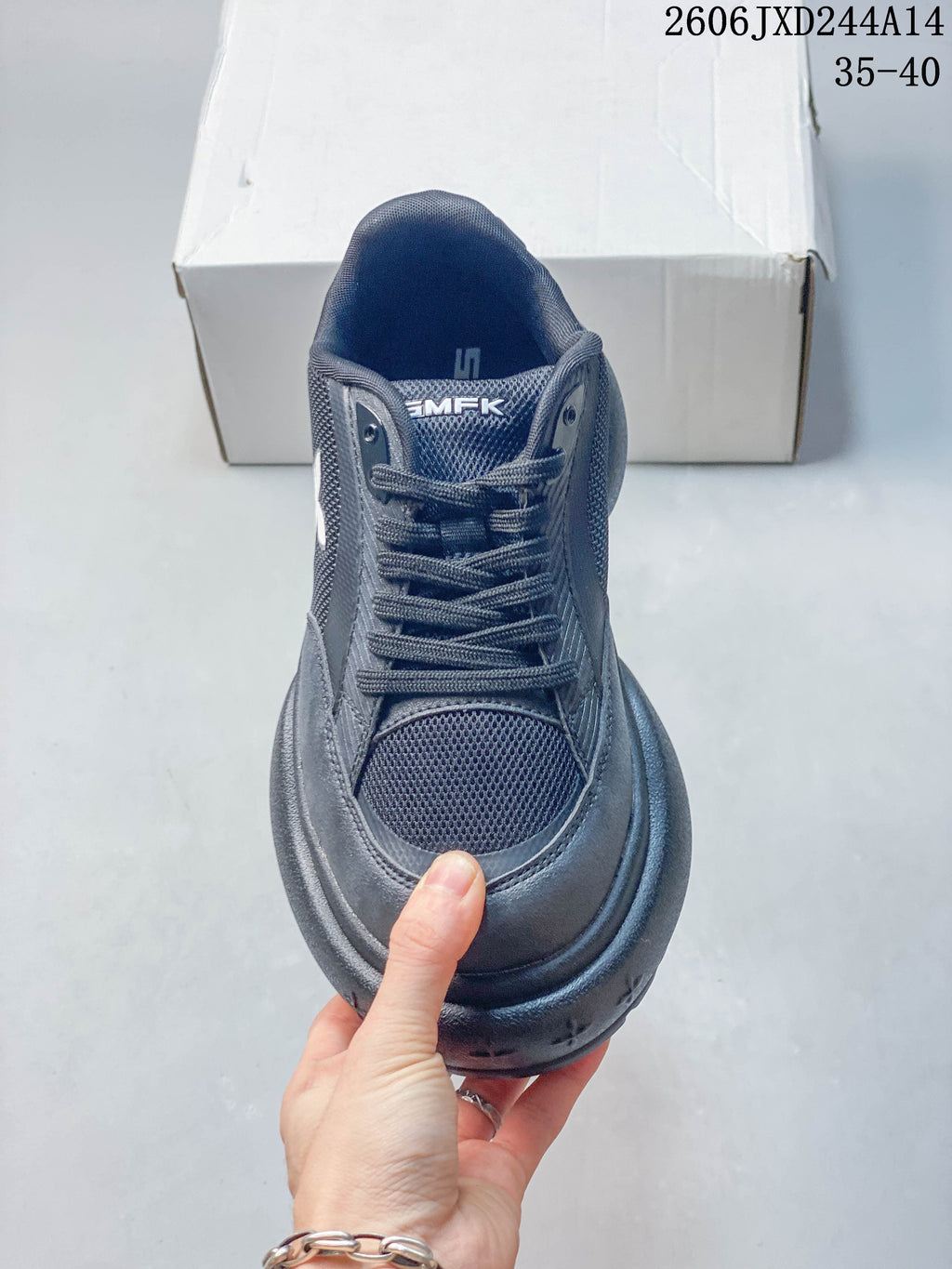 Front view of a charcoal lace-up sneaker with mesh-look toe panel and SMFK tongue branding.