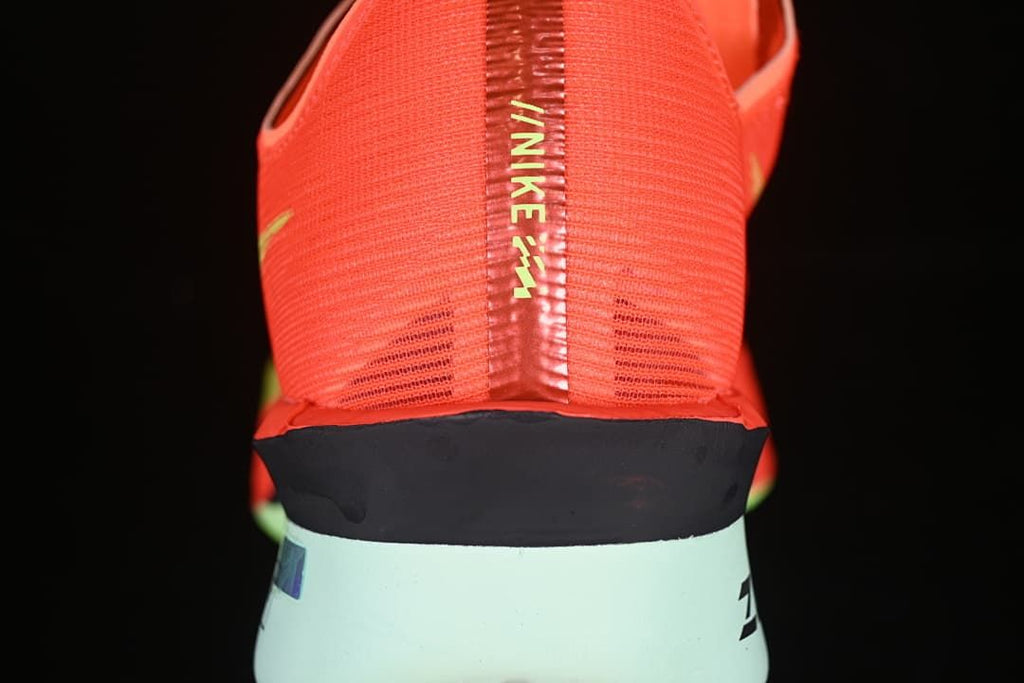 Rear view showing the coral heel, dark midsole band and pale mint-colored heel section.