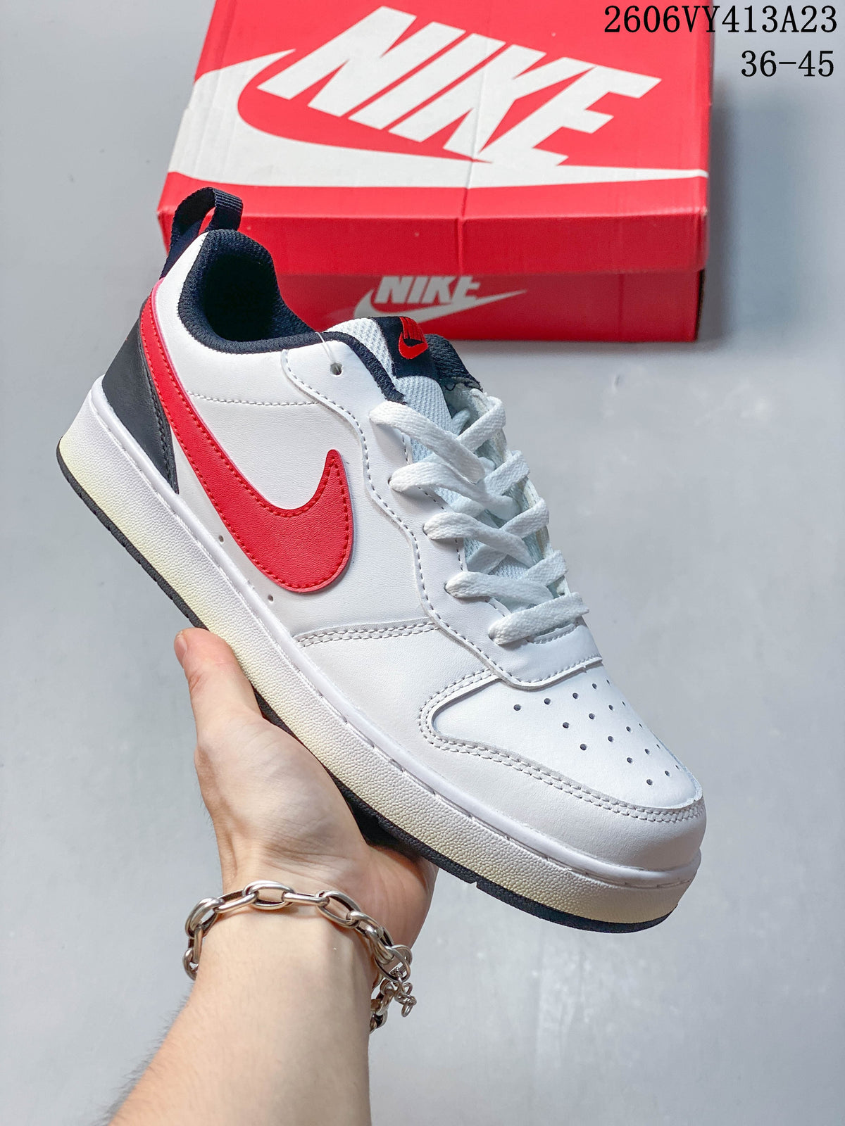 White sneaker with a red Swoosh, dark heel panel, and navy collar