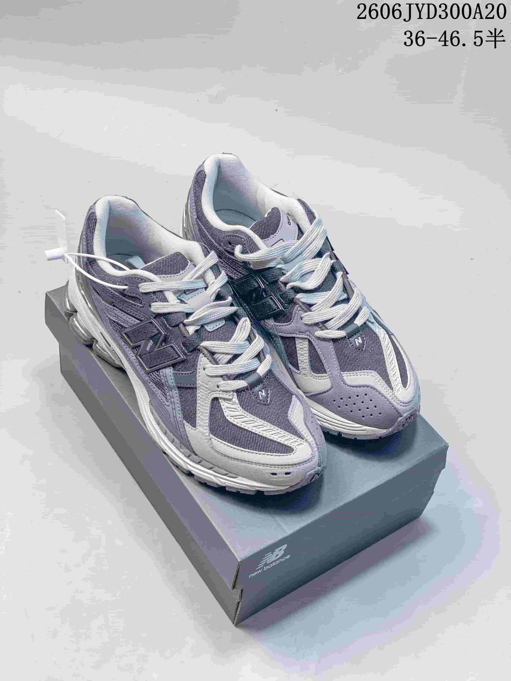Pair of grey New Balance 1906 sneakers on a shoebox