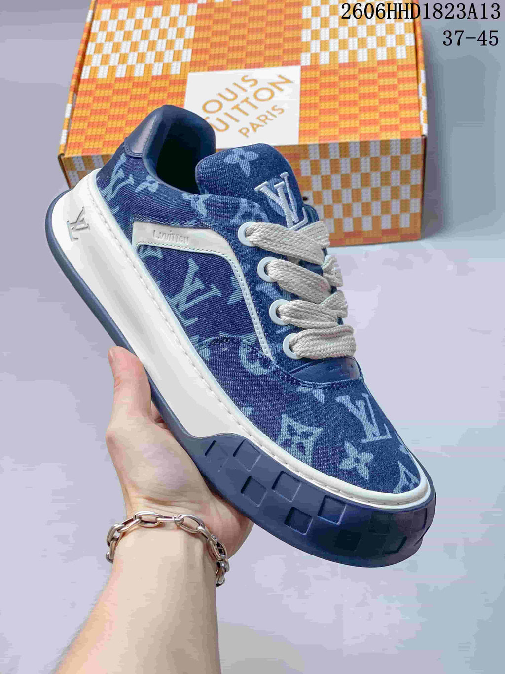 Angled side view of a blue patterned low-top sneaker with white laces, contrast trim, and a dark blue outsole.