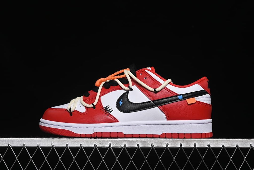 Side view of red, white, and black Nike SB Dunk Low sneakers with contrasting laces