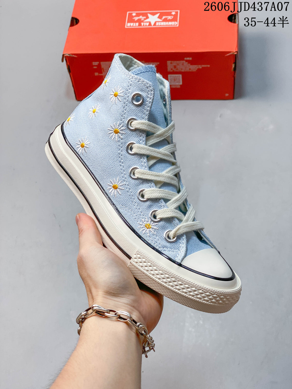 Side view of the high-top sneaker with embroidered daisies and a contrasting sole stripe