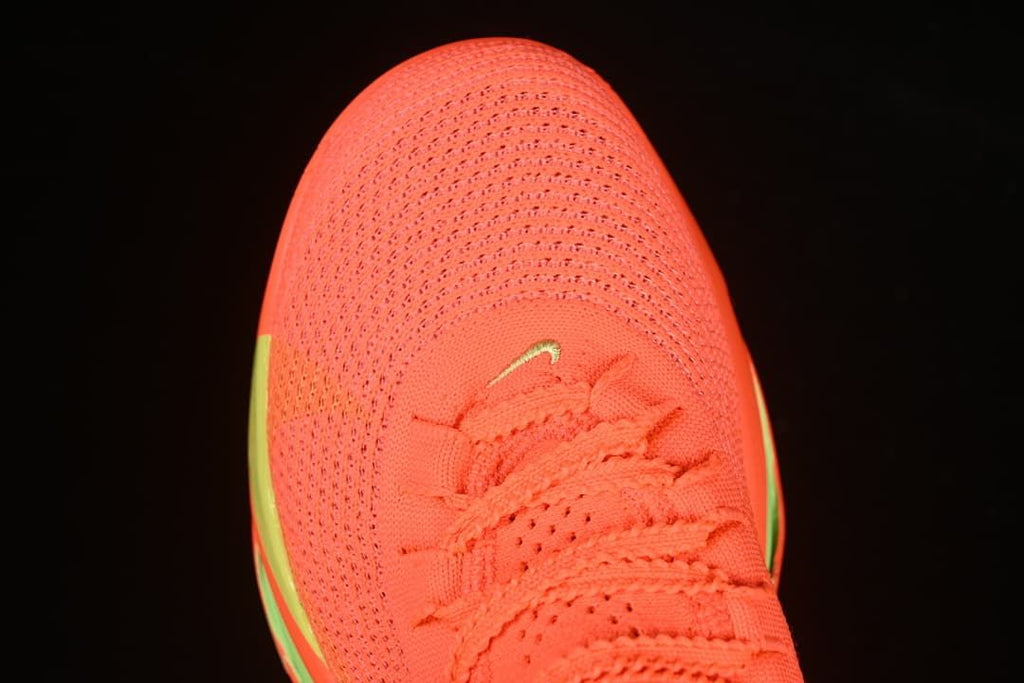 Top view of the coral-orange perforated toe box and laces
