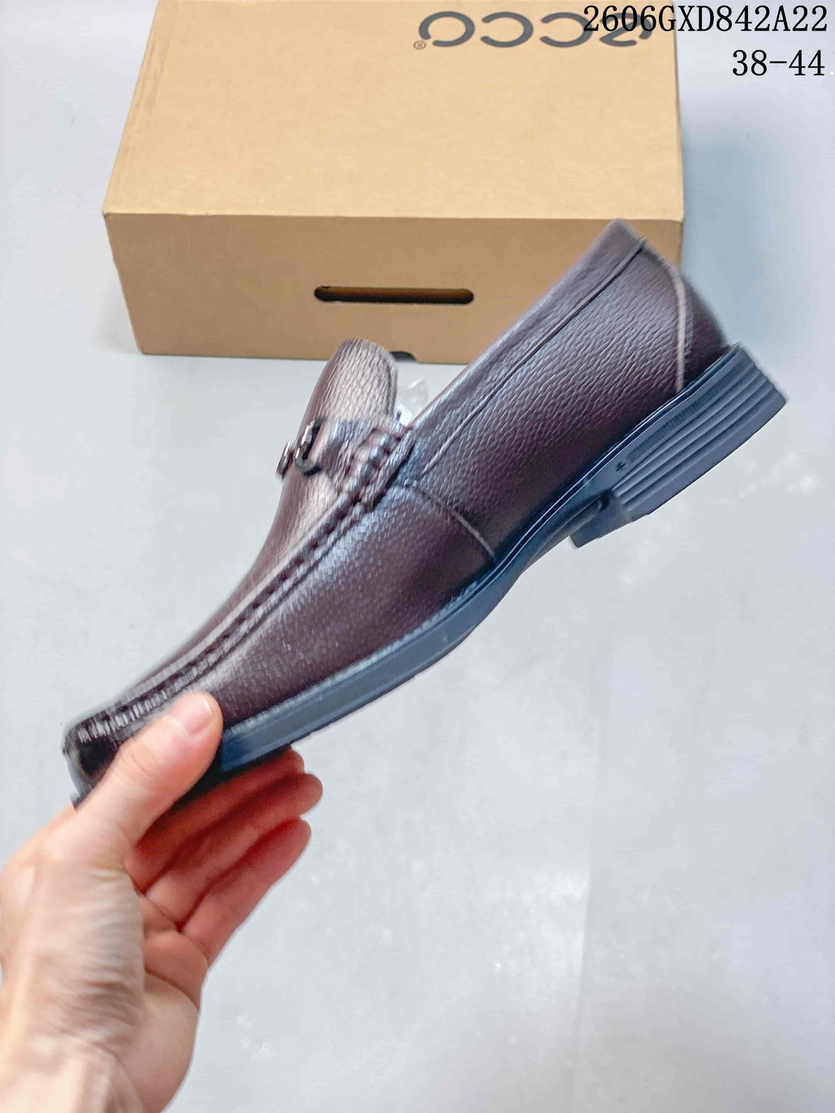 Side profile showing the brown loafer's pebbled finish, moc stitching, and dark sole