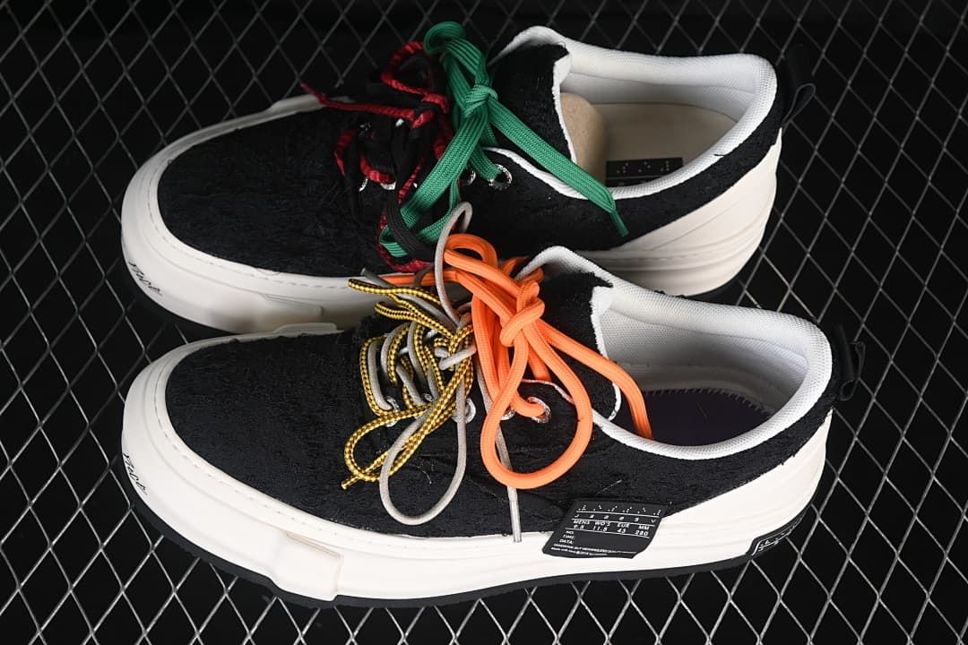 Pair of black low-top sneakers with white platform soles and colorful laces