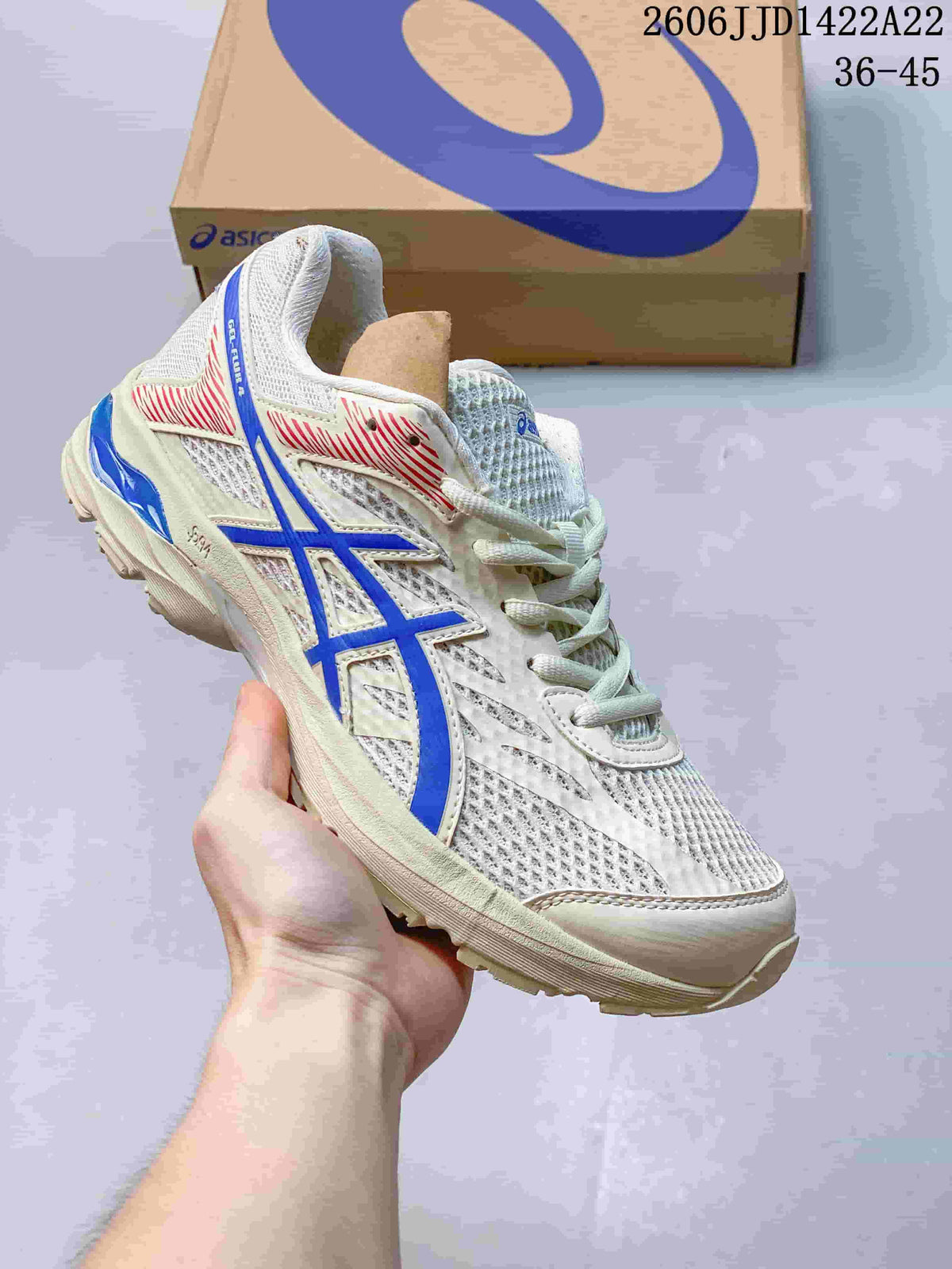 White ASICS GEL-FLUX shoe with blue accents, shown beside a shoe box.