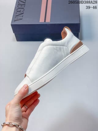 Side view of a white low-top sneaker with a tan heel accent.
