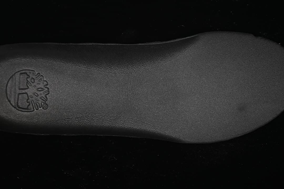 Close-up of the dark boot insole with a Timberland tree logo