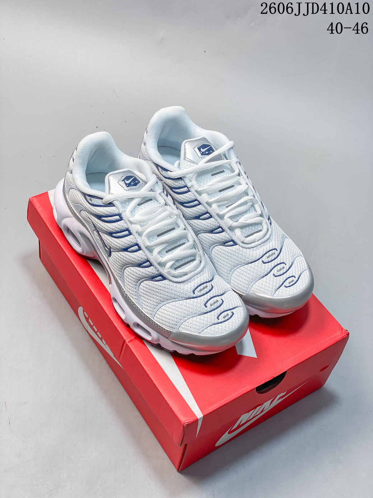 White and blue Nike Air Max 95 sneakers displayed on a red shoe box.