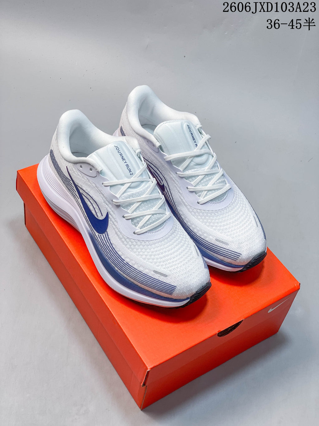 White Nike running shoes with blue accents, shown on an orange shoe box; image overlay lists sizes 36–45.