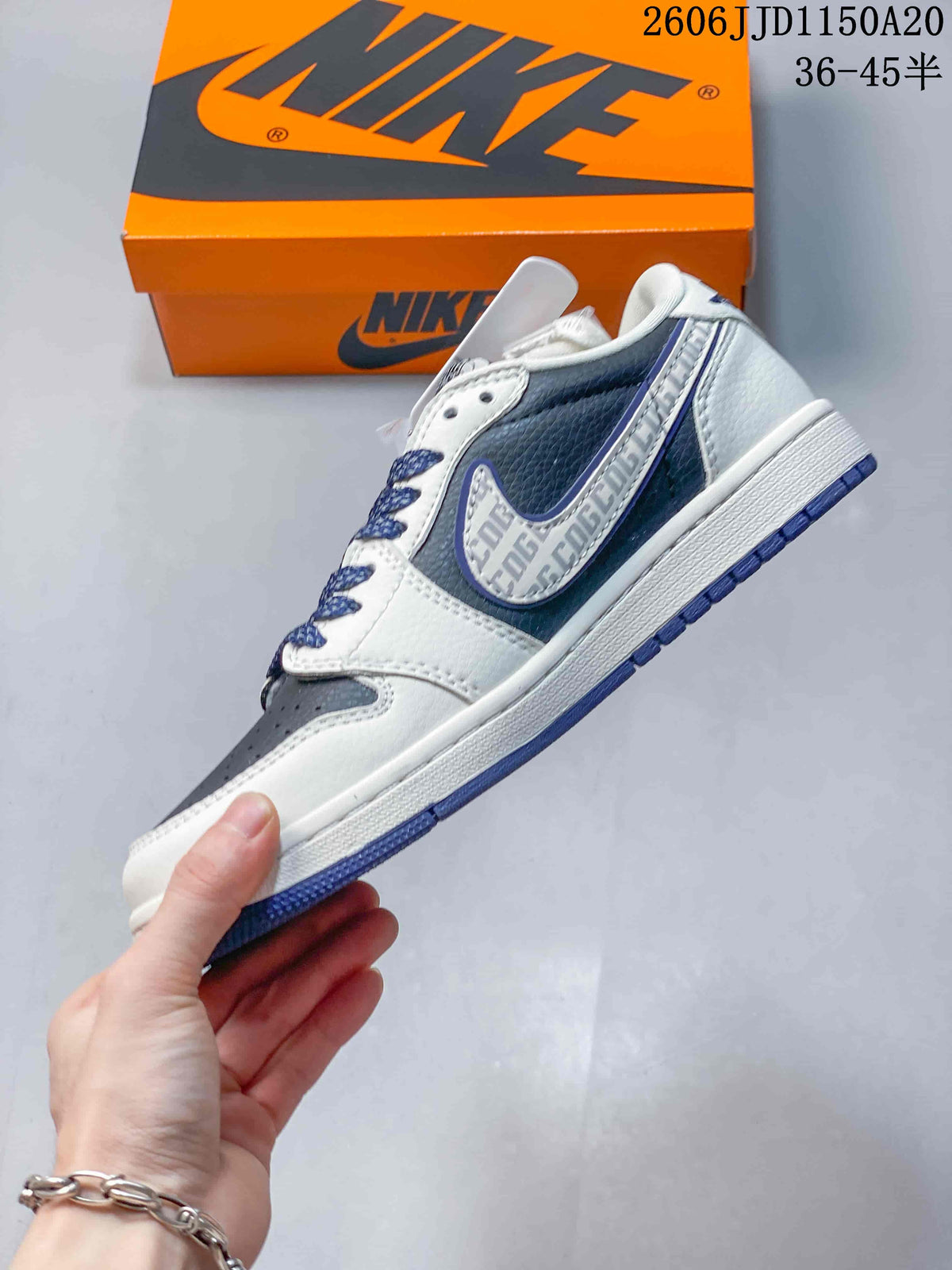 Side view of the sneaker with white overlays, navy panels, and a patterned side graphic.