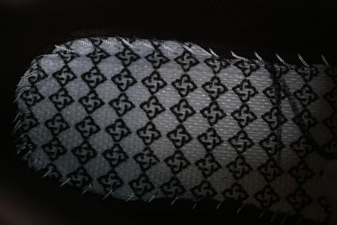 Close-up of a patterned insert or lining piece beside the boot.
