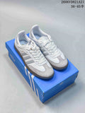 Pair of white and grey adidas Samba low-top sneakers on a blue shoe box